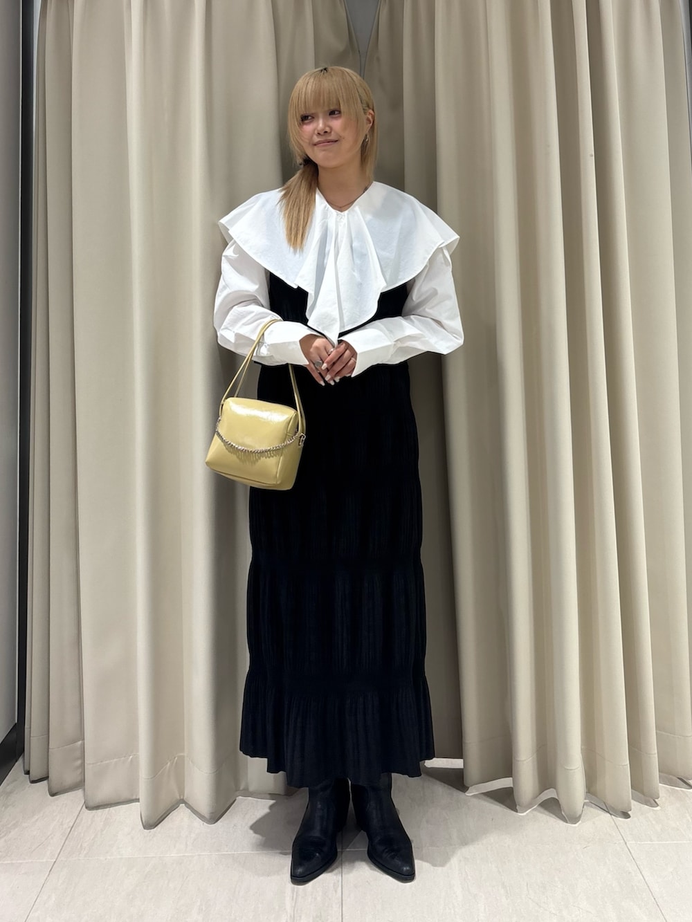 ホワイト系のシャツ/ブラウス、ブラック系のセットアップ、ベージュ系のショルダーバッグを着用したレディースの春コーディネートの3枚目の写真