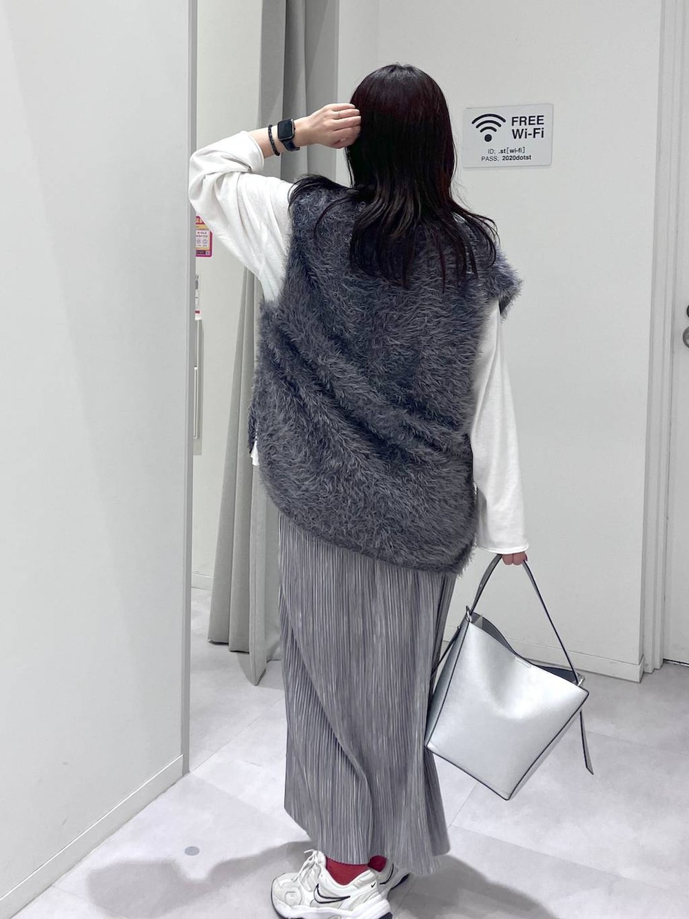 シルバー系のショルダーバッグ、グレー系のスカート、グレー系のベストを着用したレディースの秋コーディネートの9枚目の写真