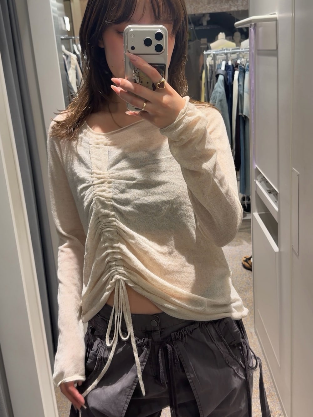 ホワイト系のニット/セーター、ブラック系のスラックス、ブラック系のスニーカーを着用したレディースの春コーディネートの2枚目の写真