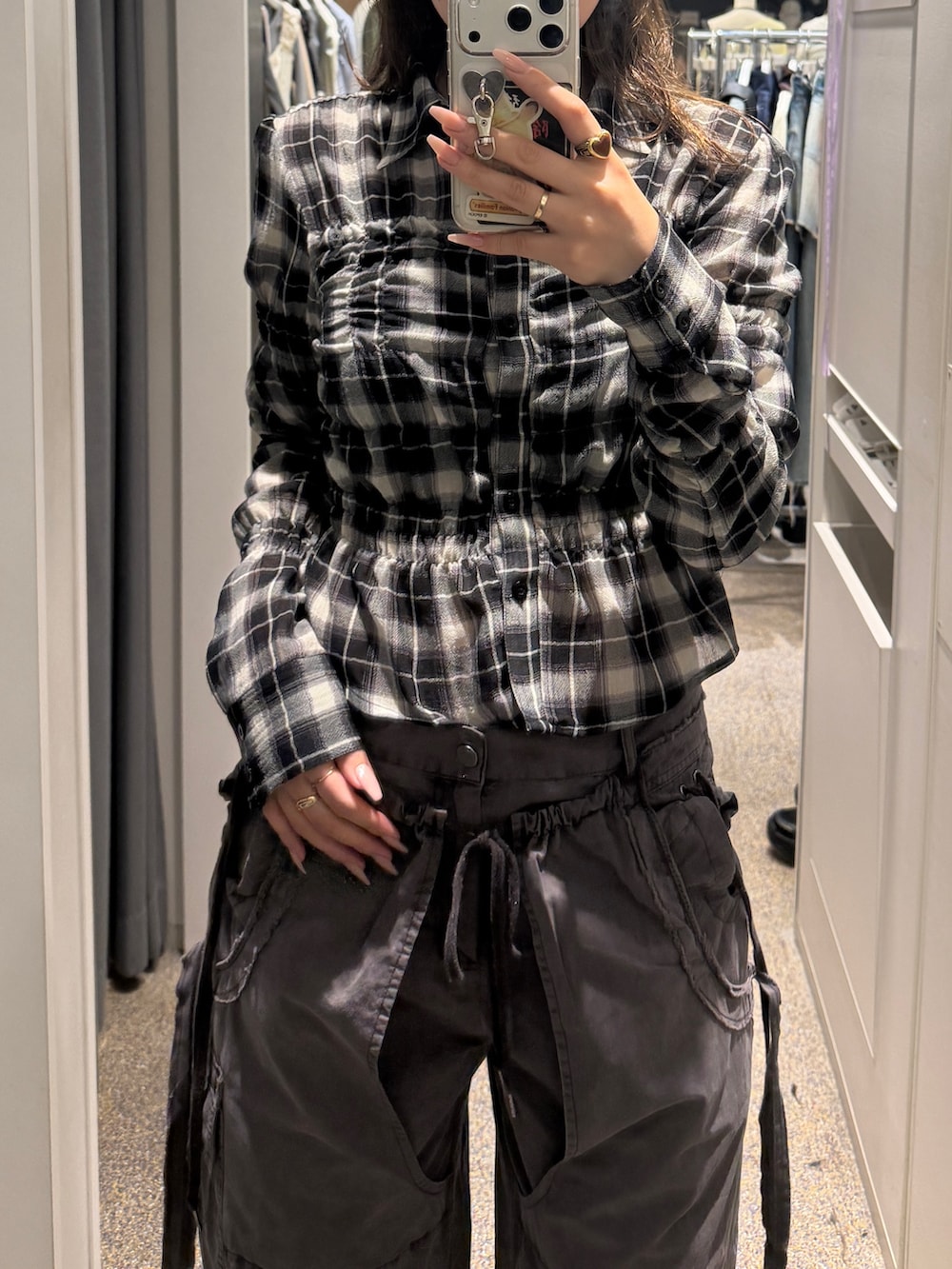 ブラック系のシャツ/ブラウス、ブラック系のスラックス、ブラック系のスニーカーを着用したレディースの春コーディネートの2枚目の写真