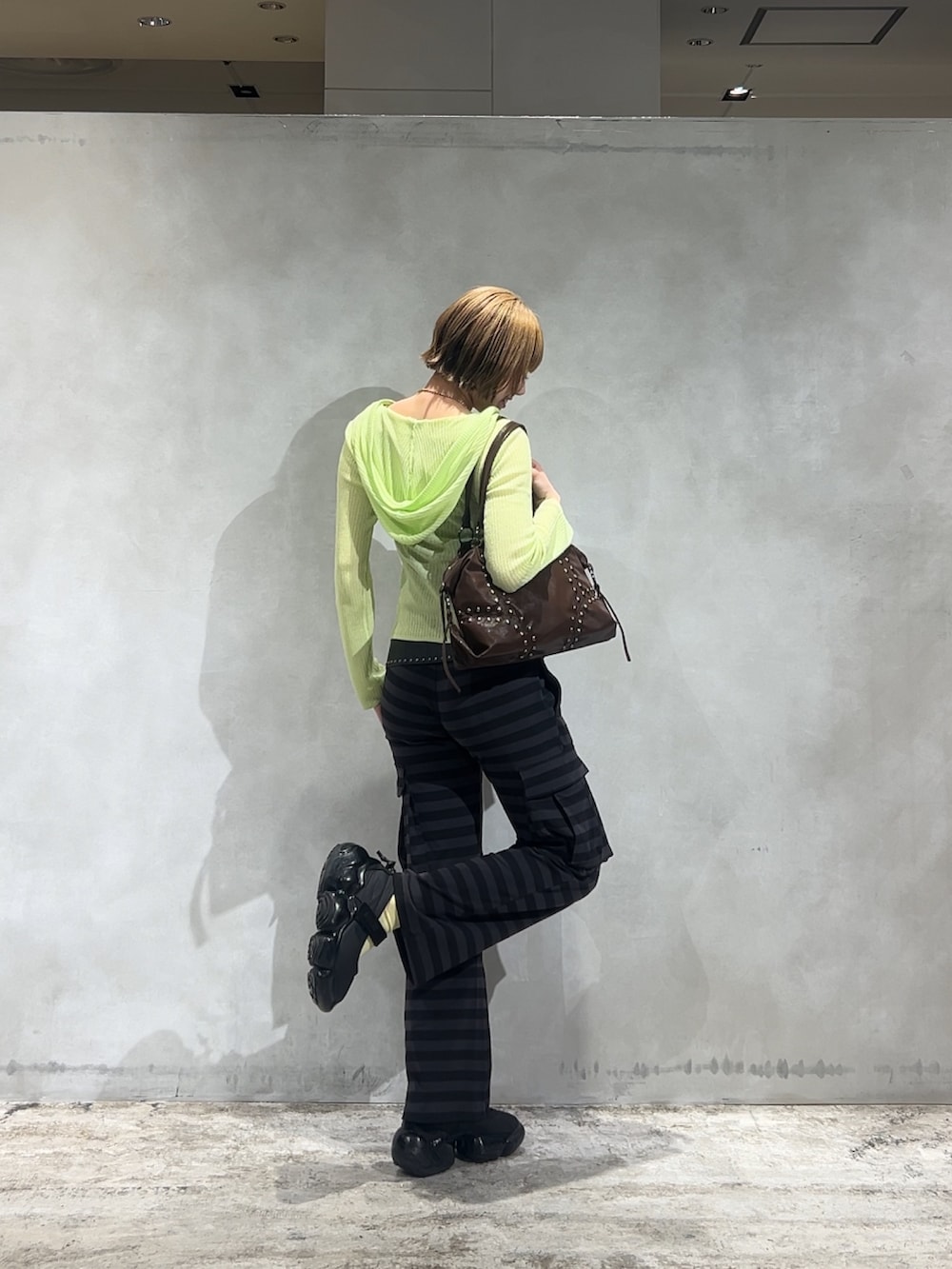 グレー系のその他パンツ、イエロー系のカーディガン/ボレロ、ブラック系のキャミソールを着用したレディースの春コーディネートの2枚目の写真