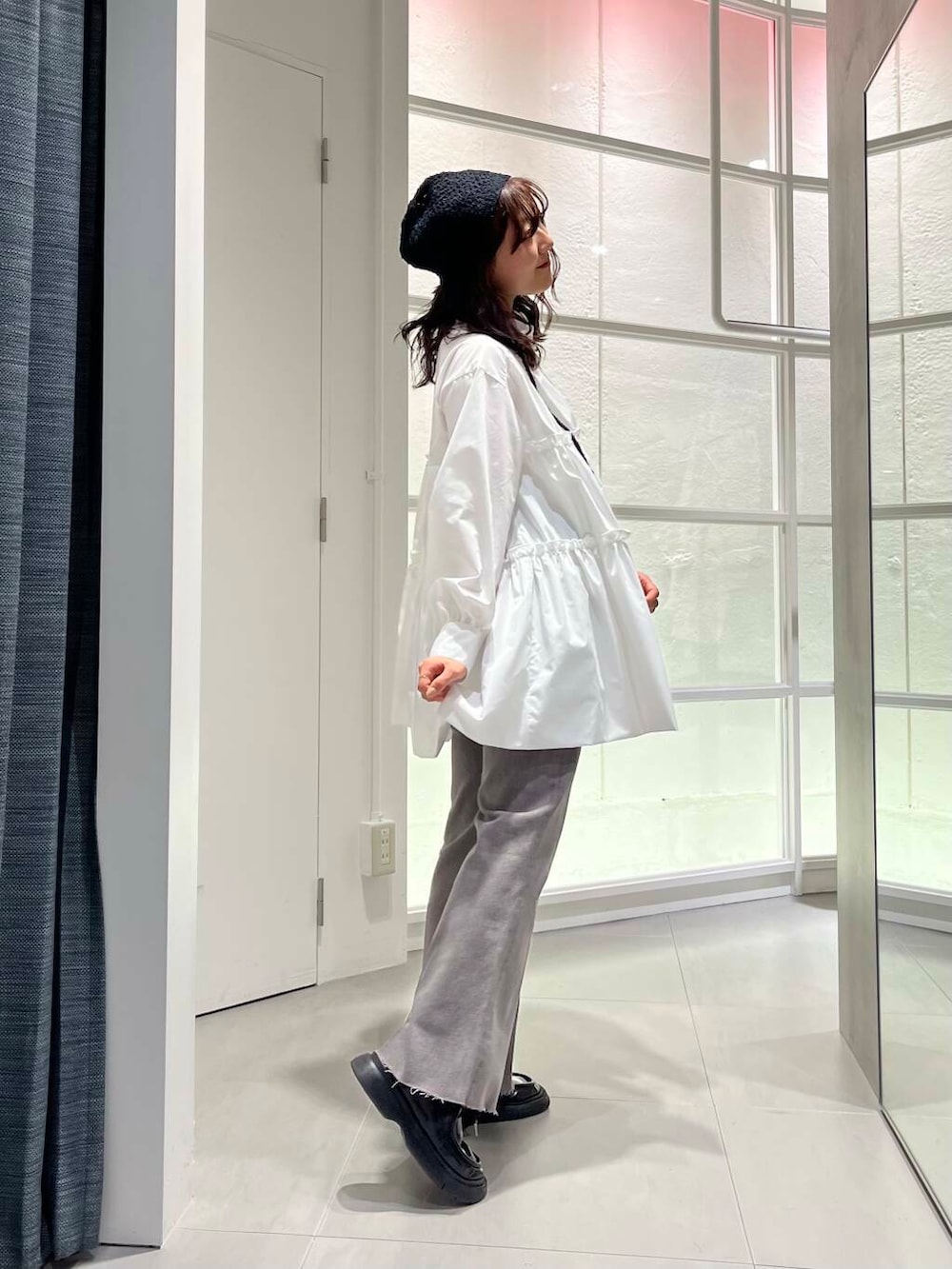 ブラック系のローファー、ホワイト系のワンピース、グレー系のデニムパンツを着用したレディースの冬コーディネートの5枚目の写真