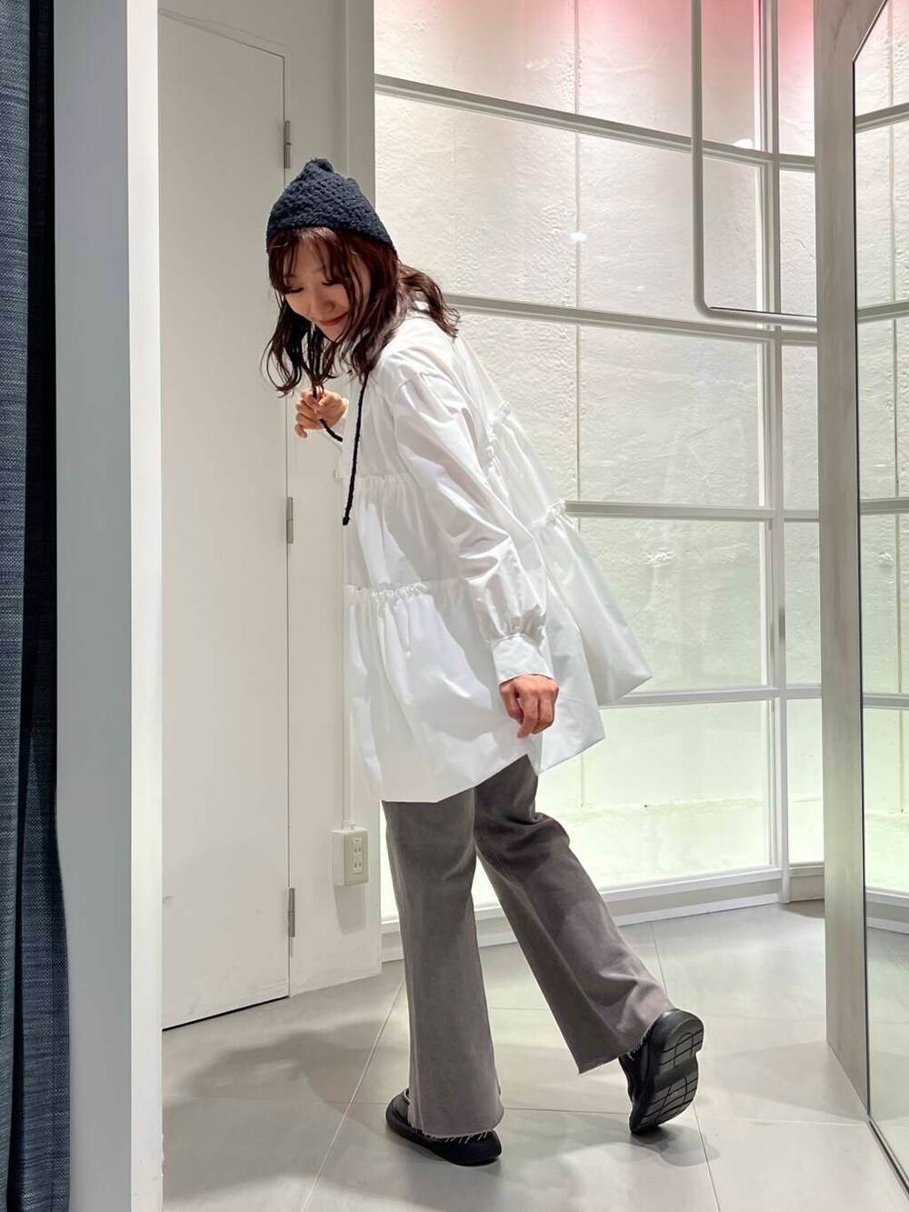 ブラック系のローファー、ホワイト系のワンピース、グレー系のデニムパンツを着用したレディースの冬コーディネートの7枚目の写真