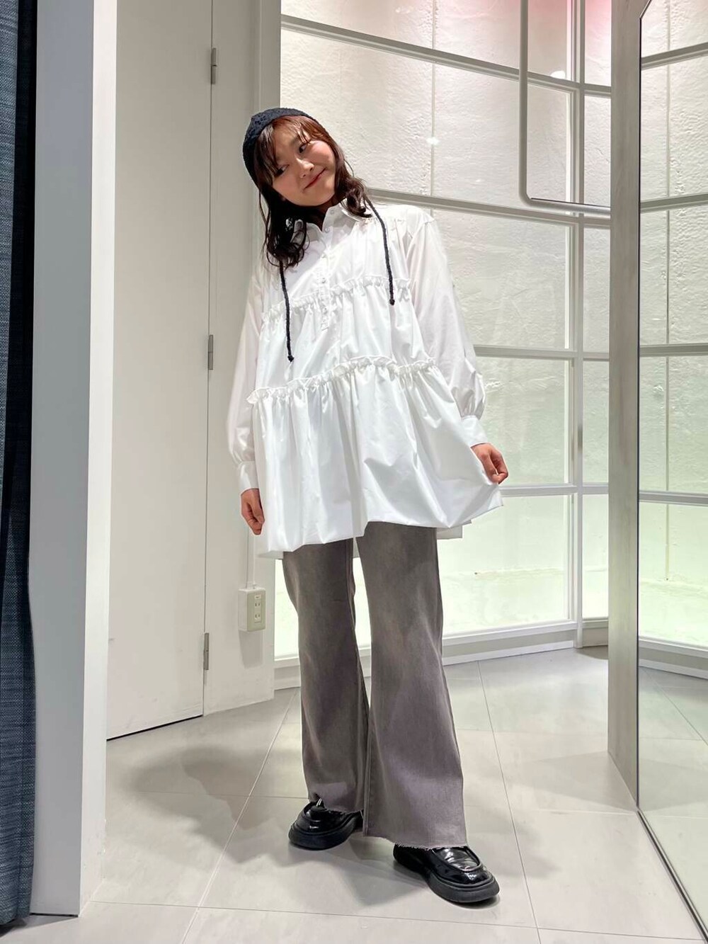 ブラック系のローファー、ホワイト系のワンピース、グレー系のデニムパンツを着用したレディースの冬コーディネートの8枚目の写真