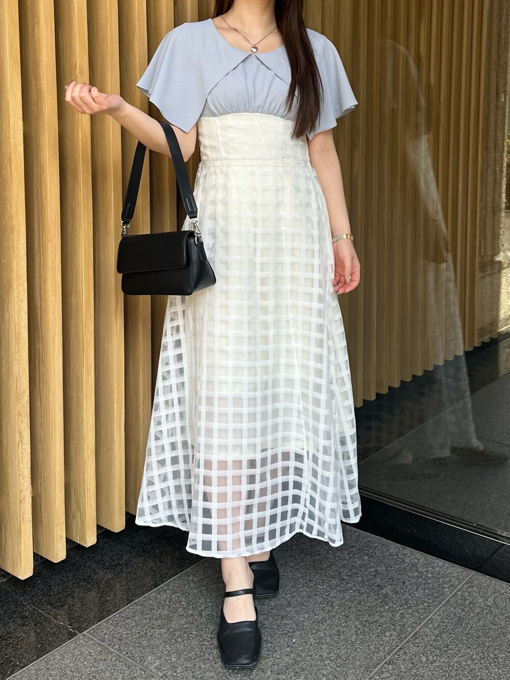 ブルー系のワンピースを着用したレディースの春コーディネートの2枚目の写真