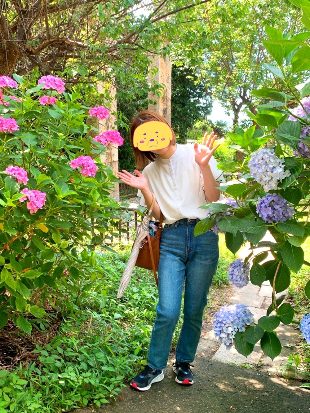 ブラック系のスニーカー、ブルー系のデニムパンツ、ホワイト系のシャツ/ブラウスを着用したレディースの夏コーディネートの2枚目の写真