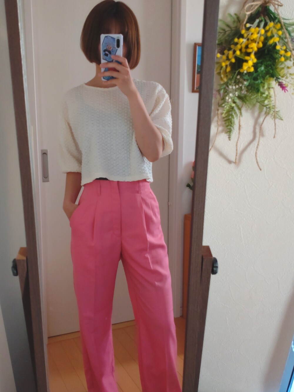 ホワイト系のスラックス、ホワイト系のTシャツ/カットソー、ブラウン系のショルダーバッグを着用したレディースの春コーディネートの2枚目の写真
