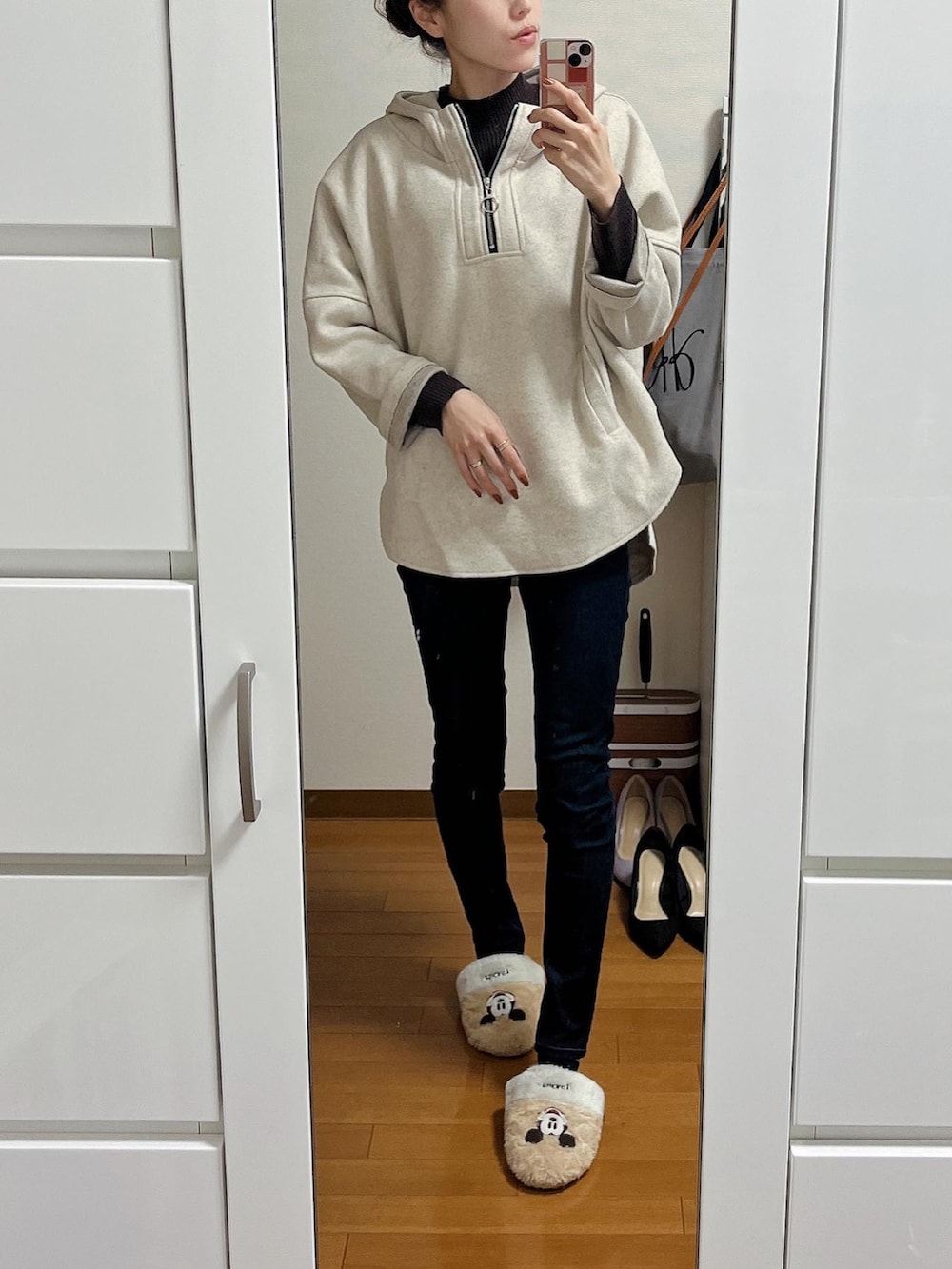 グレー系のパーカー、ブルー系のデニムパンツ、ブラウン系のニット/セーターを着用したレディースの冬コーディネートの2枚目の写真