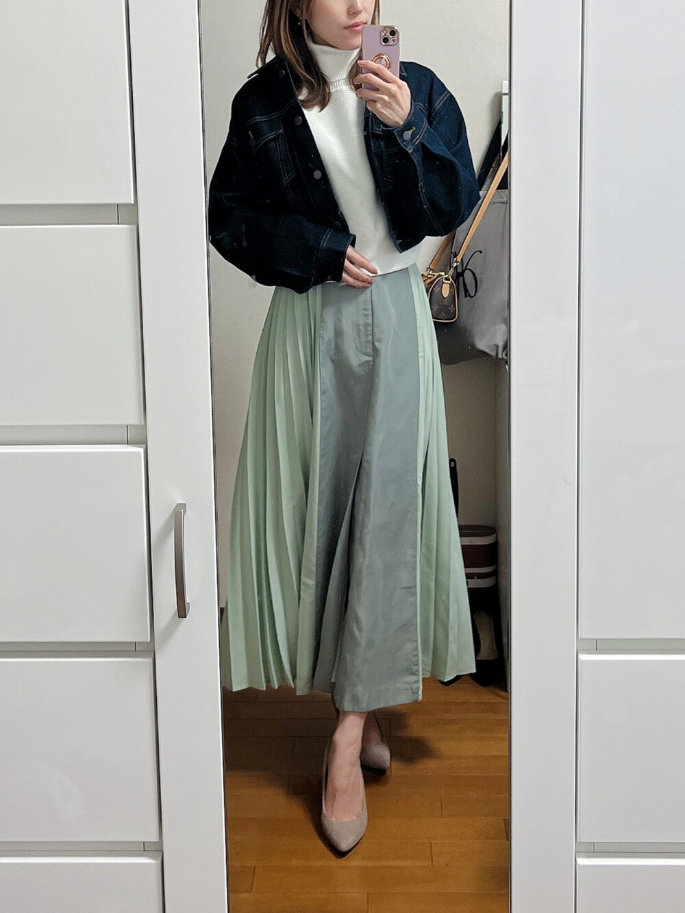 ベージュ系のパンプス、ホワイト系のニット/セーター、グリーン系のスカートを着用したレディースの春コーディネートの2枚目の写真