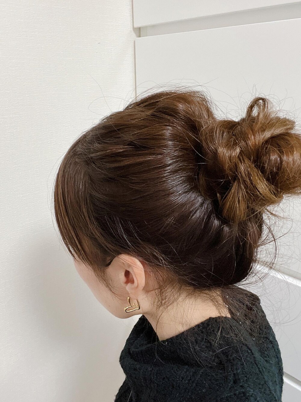 ブラック系のニット/セーター、ホワイト系のデニムパンツ、ブラック系のブーツを着用したレディースの秋コーディネートの3枚目の写真