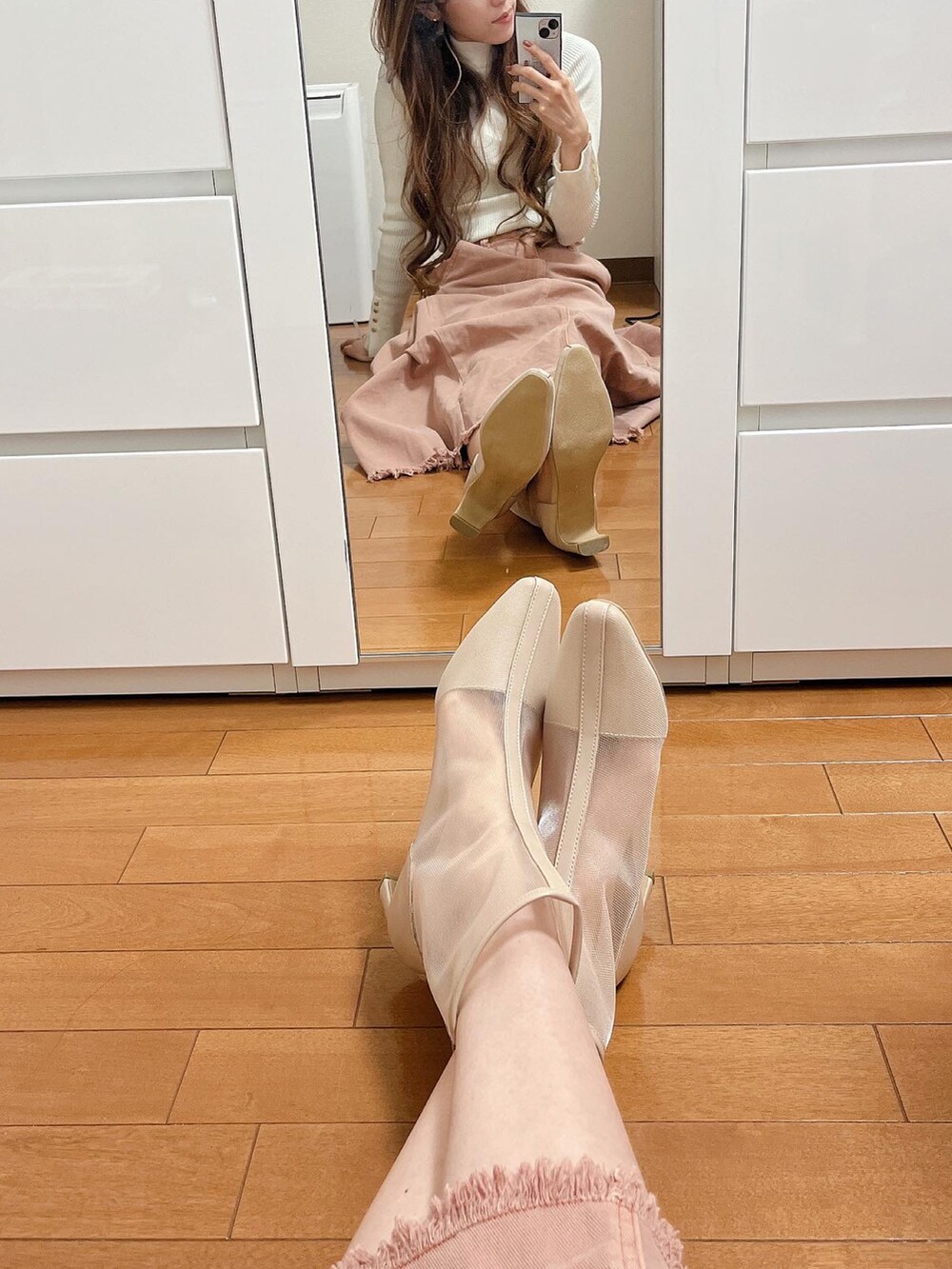 ホワイト系のニット/セーター、オレンジ系のスカート、ベージュ系のブーツを着用したレディースの春コーディネートの2枚目の写真