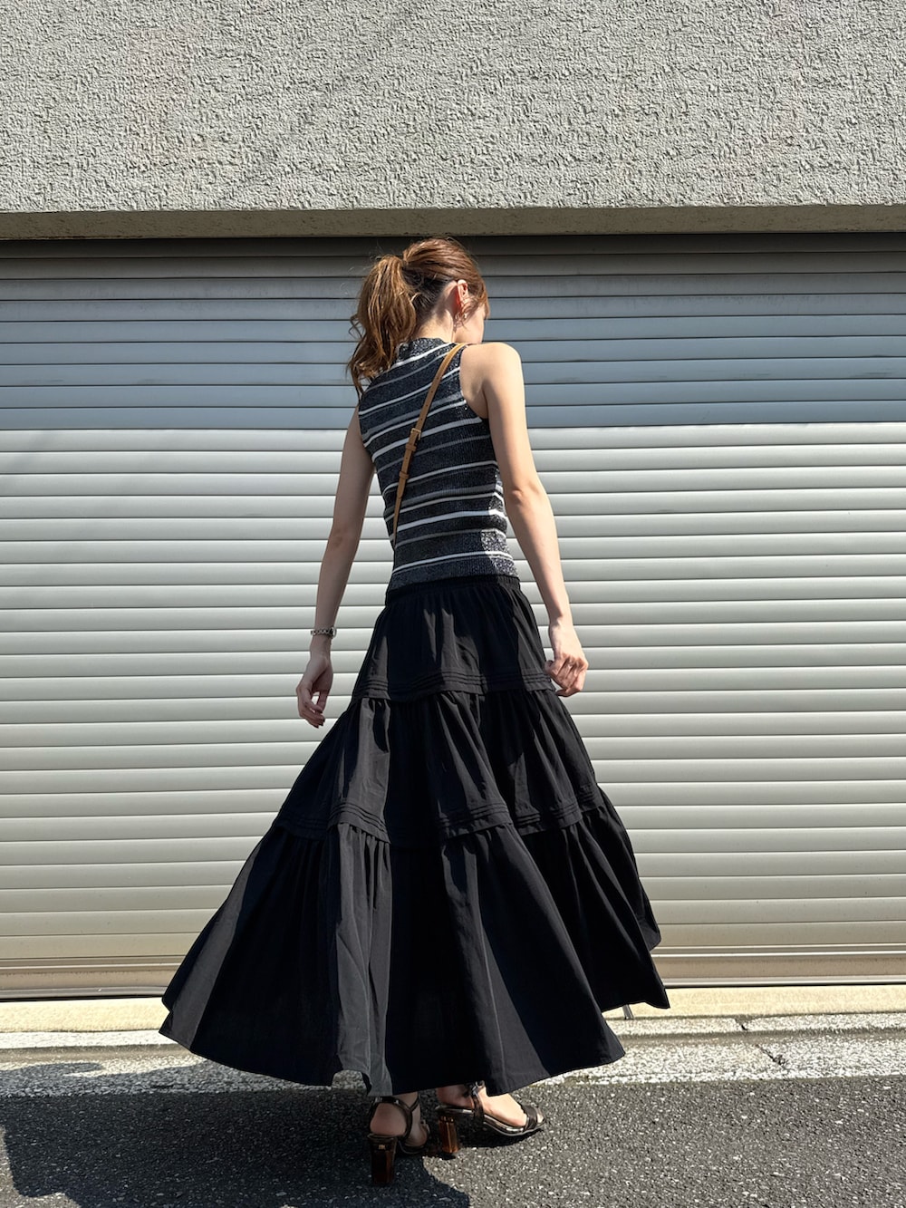 ブラック系のニット/セーター、ブラック系のスカート、その他のサンダルを着用したレディースの夏コーディネートの3枚目の写真