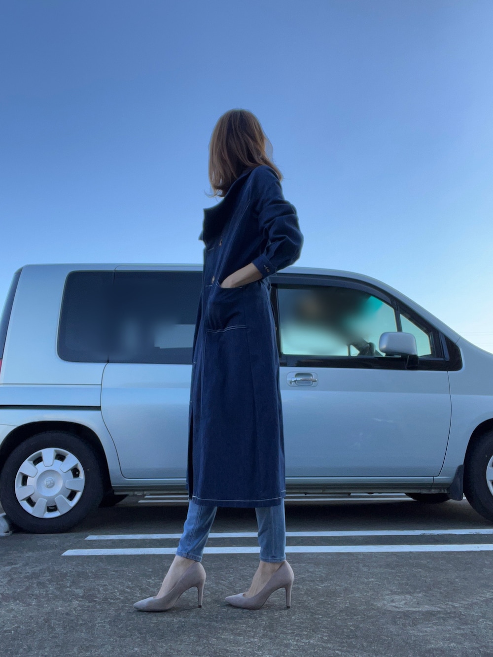 ブルー系のトレンチコート、ブルー系のデニムパンツ、ベージュ系のパンプスを着用したレディースの秋コーディネートの2枚目の写真