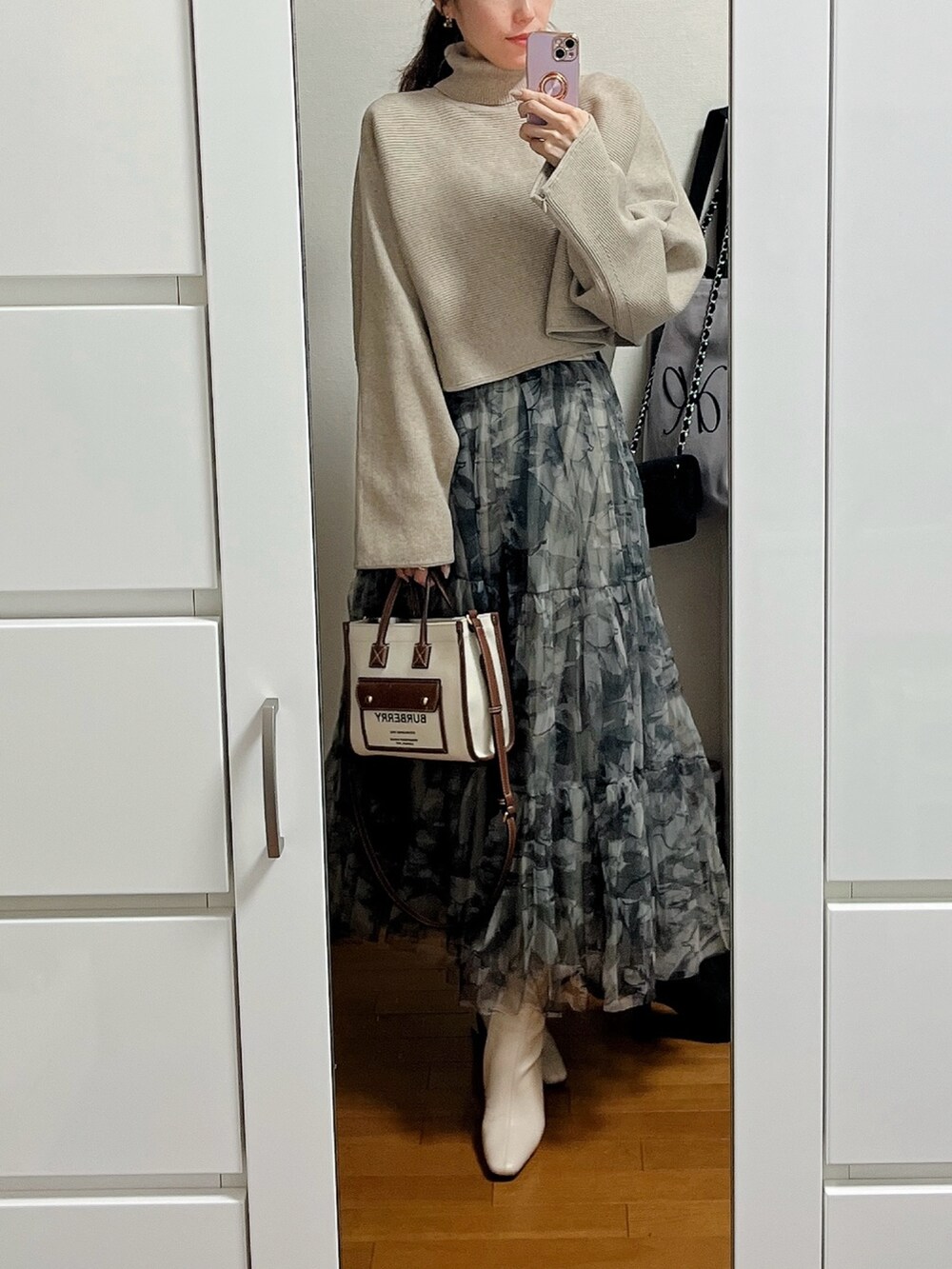 ベージュ系のニット/セーター、ホワイト系のダウンジャケット/コート、その他のスカートを着用したレディースの冬コーディネートの2枚目の写真