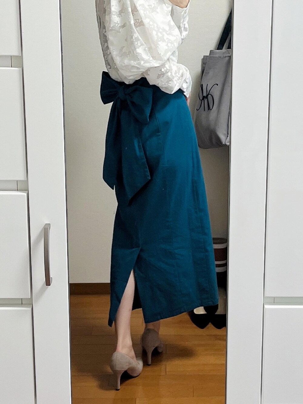 ホワイト系のシャツ/ブラウス、ブルー系のスカート、ベージュ系のハンドバッグを着用したレディースの春コーディネートの2枚目の写真