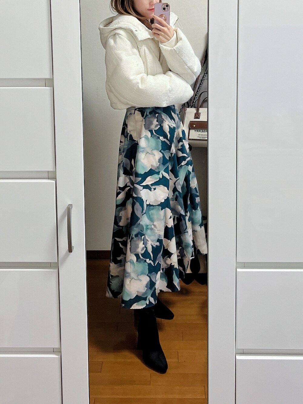 ブラック系のニット/セーター、ブルー系のスカート、ブラック系のブーツを着用したレディースの冬コーディネートの2枚目の写真