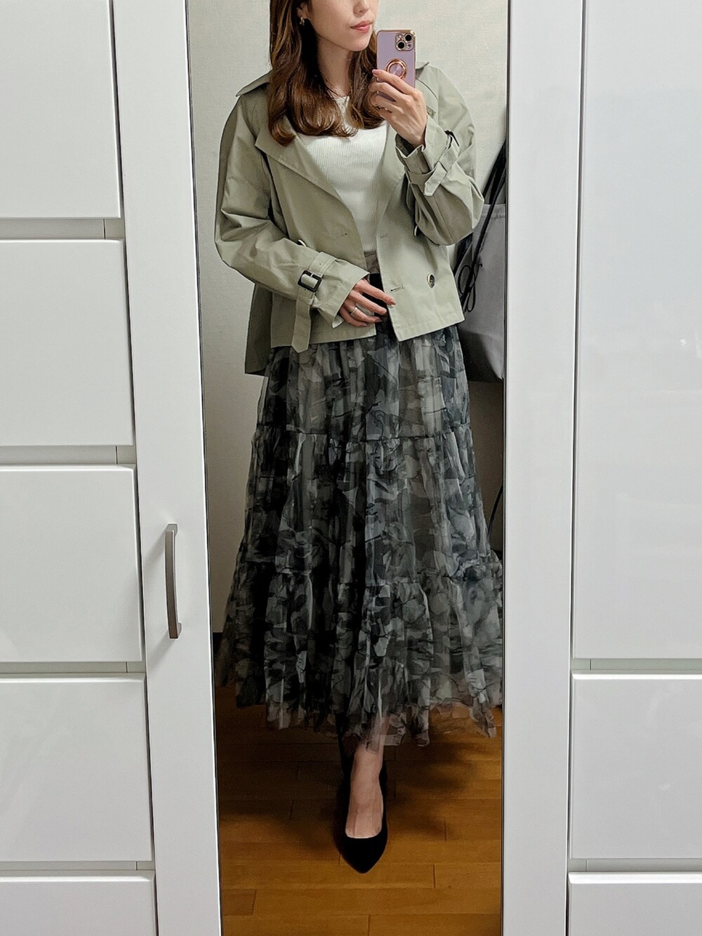 グリーン系のステンカラーコート、その他のスカート、ブラック系のパンプスを着用したレディースの春コーディネートの2枚目の写真