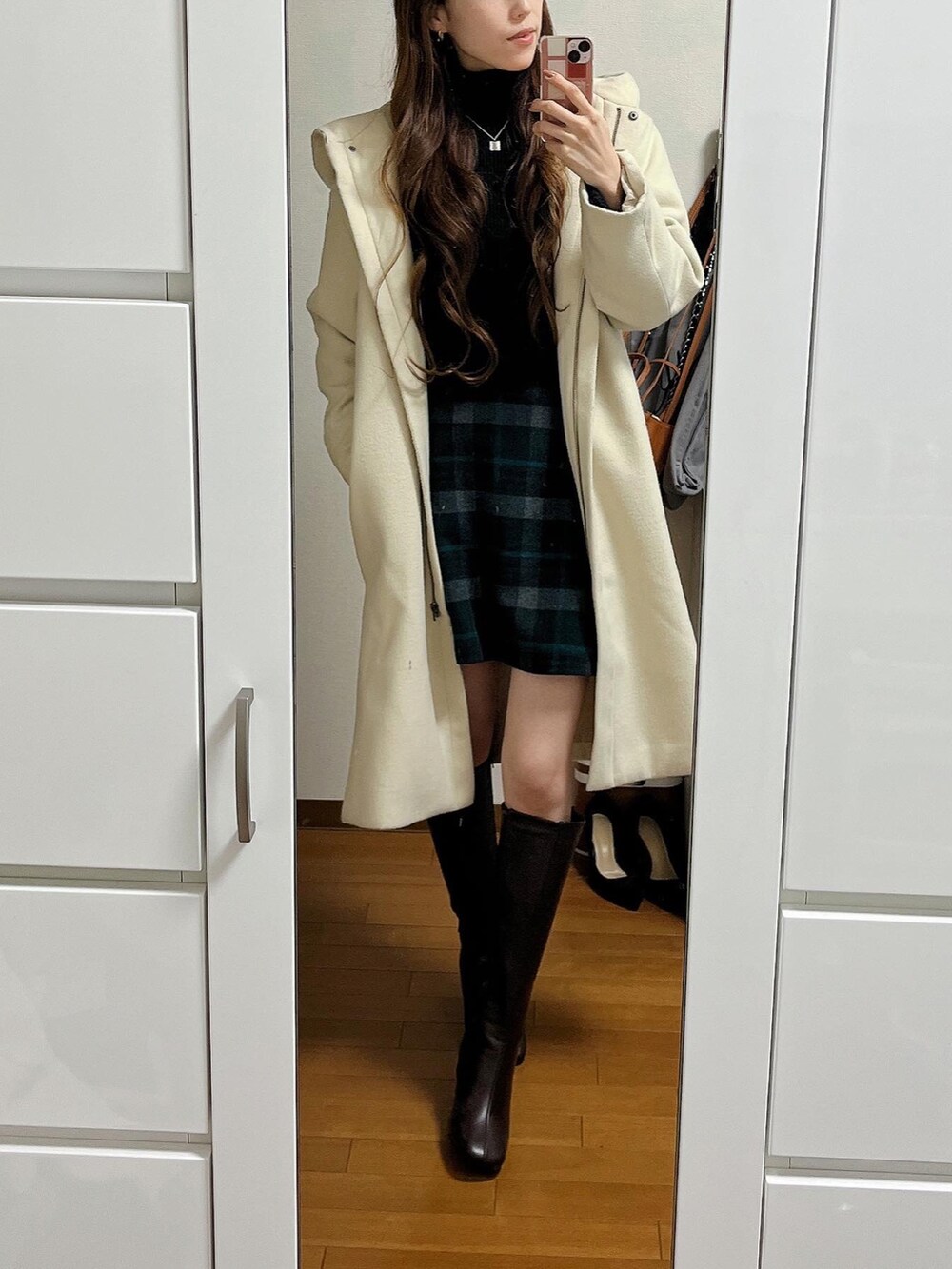 ブラック系のニット/セーター、グリーン系のスカート、イエロー系のショルダーバッグを着用したレディースの冬コーディネートの2枚目の写真