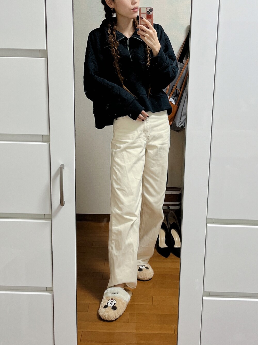 ブラック系のスウェット、ベージュ系のデニムパンツを着用したレディースの冬コーディネートの2枚目の写真