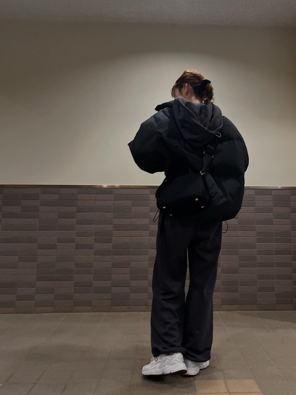 ブラック系のスウェット、ブラック系のスウェットパンツ、ホワイト系のスニーカーを着用したレディースの冬コーディネートの2枚目の写真
