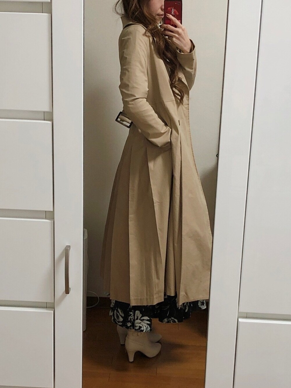 ホワイト系のニット/セーター、ブラック系のスカート、ベージュ系のトレンチコートを着用したレディースの冬コーディネートの2枚目の写真