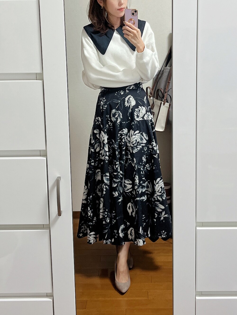 ブラック系のブルゾン、ブラック系のスカート、ベージュ系のパンプスを着用したレディースの秋コーディネートの2枚目の写真