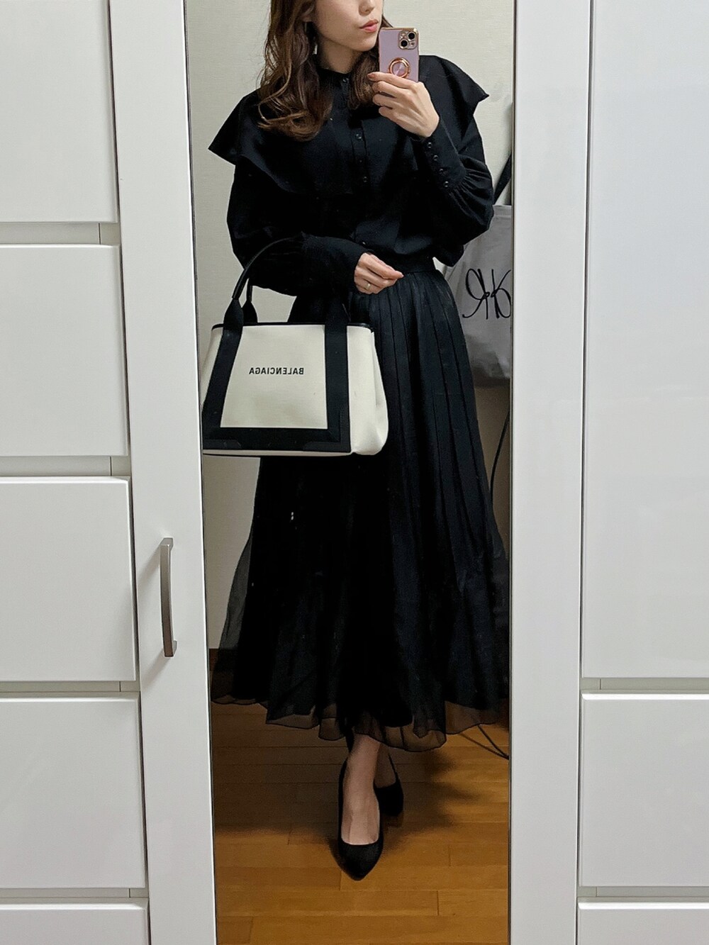 ブラック系のシャツ/ブラウス、ブラック系のスカート、ブラック系のパンプスを着用したレディースの春コーディネートの2枚目の写真