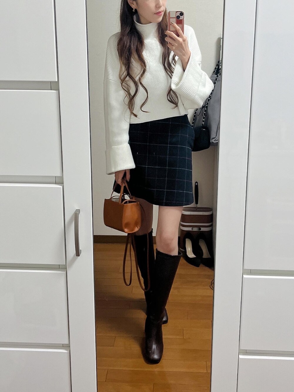 ホワイト系のニット/セーター、グレー系のスカート、イエロー系のショルダーバッグを着用したレディースの冬コーディネートの2枚目の写真