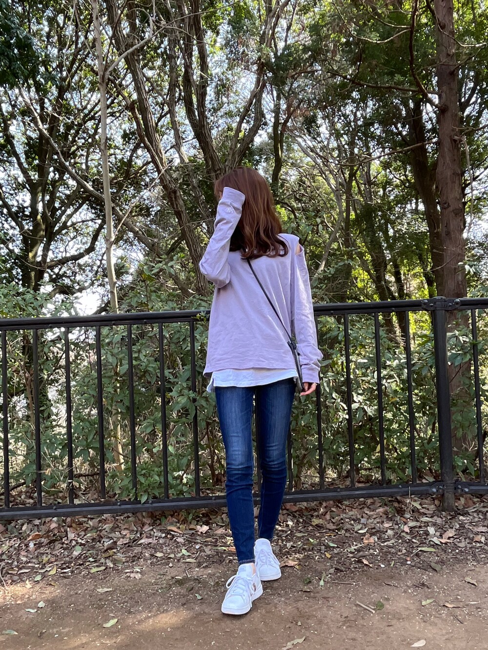 パープル系のTシャツ/カットソー、ブルー系のデニムパンツ、ホワイト系のスニーカーを着用したレディースの春コーディネートの2枚目の写真