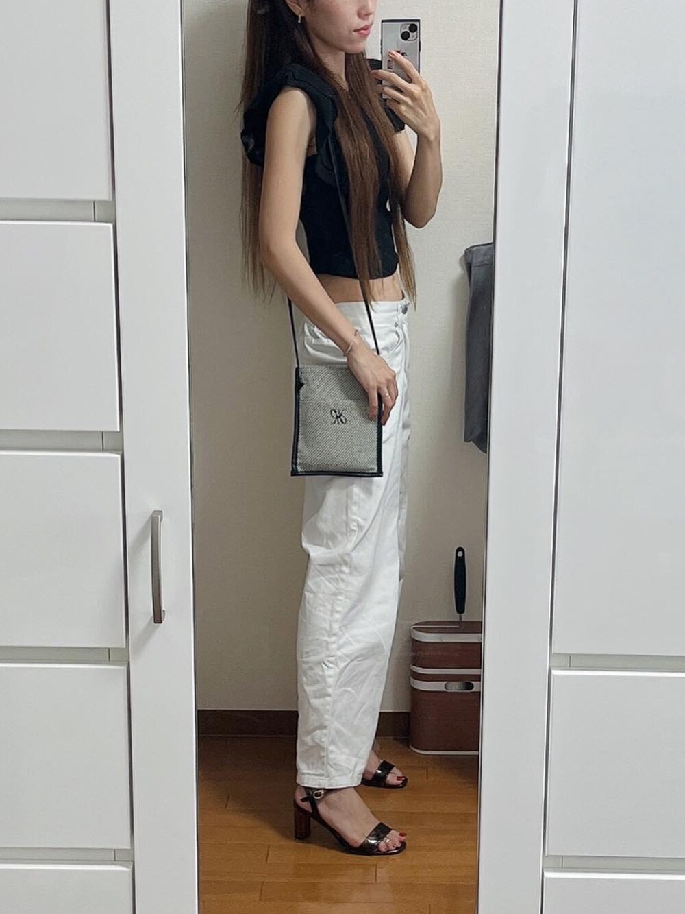 ブラック系のTシャツ/カットソー、ブラック系のショルダーバッグ、ホワイト系のその他パンツを着用したレディースの夏コーディネートの2枚目の写真