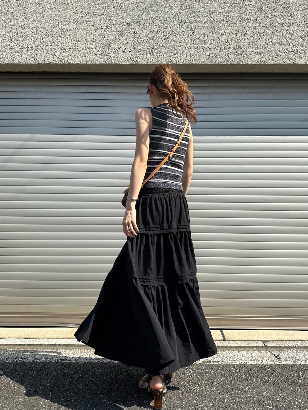 ブラック系のニット/セーター、ブラック系のスカート、その他のサンダルを着用したレディースの夏コーディネートの2枚目の写真