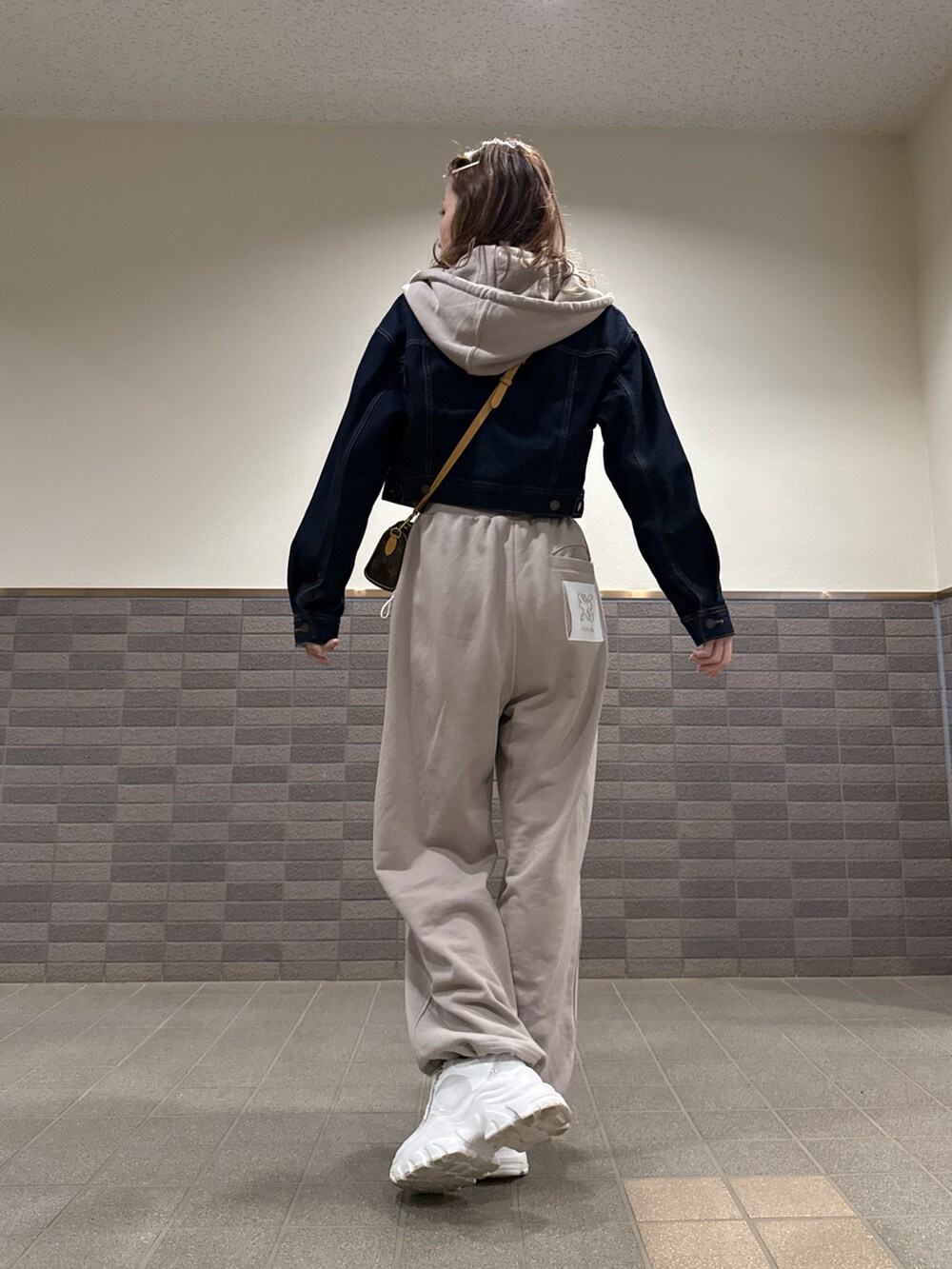 ベージュ系のスウェット、ベージュ系のスウェットパンツ、ホワイト系のスニーカーを着用したレディースの春コーディネートの2枚目の写真
