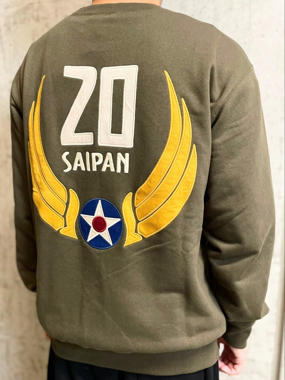 グリーン系のスウェット、ブラック系のスウェットパンツ、ブルー系のスタジャンを着用したメンズの夏コーディネートの3枚目の写真