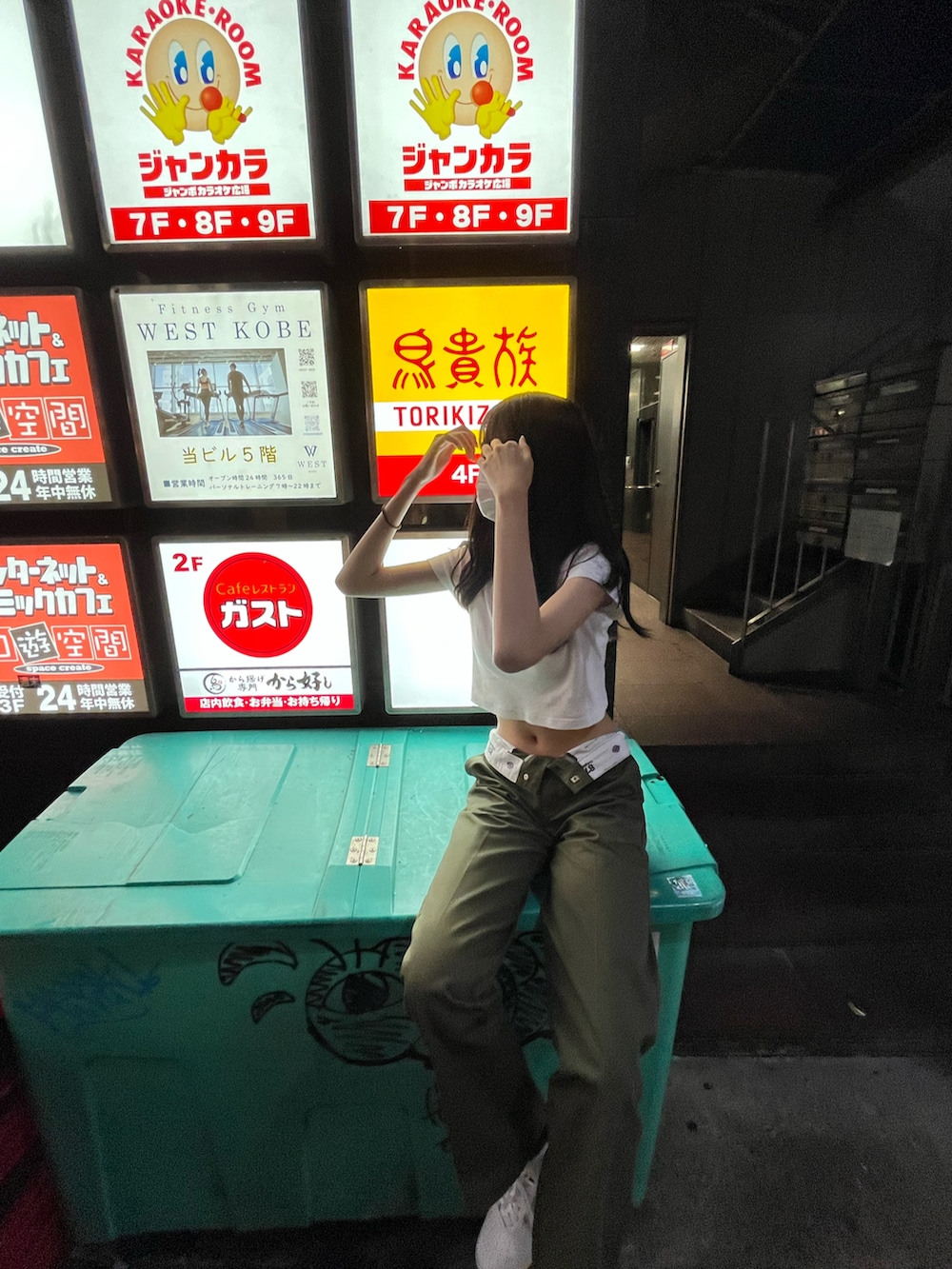 グリーン系のチノパンツ、ブラウン系のスニーカー、ホワイト系のTシャツ/カットソーを着用したレディースの夏コーディネートの2枚目の写真