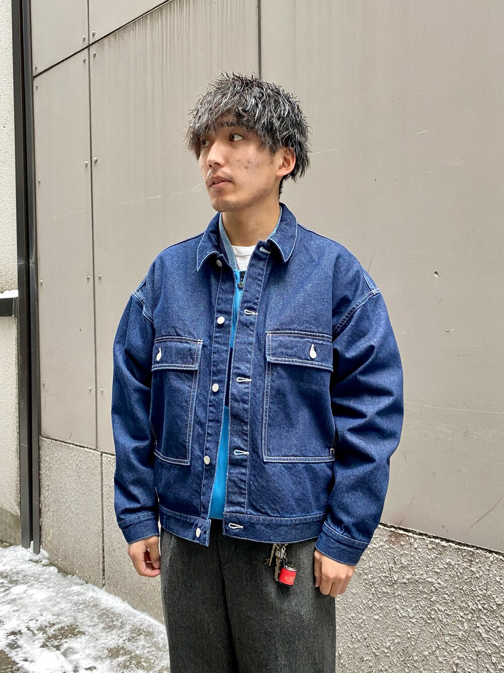 ブルー系のデニムジャケット、グレー系のスラックス、ブルー系のスニーカーを着用したメンズの冬コーディネートの2枚目の写真