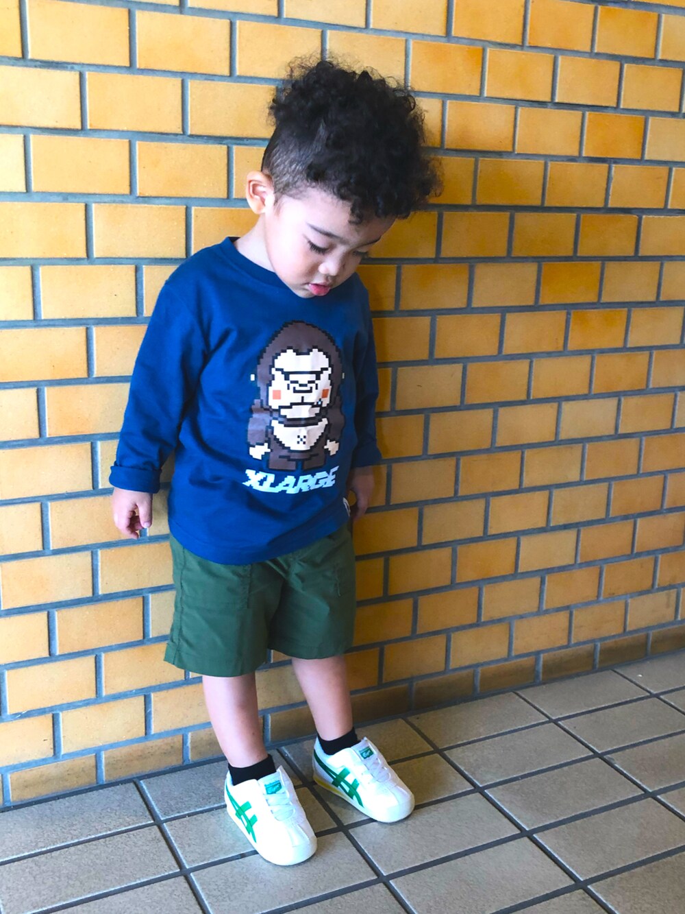 グリーン系のパンツ、ホワイト系のスニーカー、ホワイト系のTシャツ/カットソーを着用したキッズの秋コーディネートの2枚目の写真