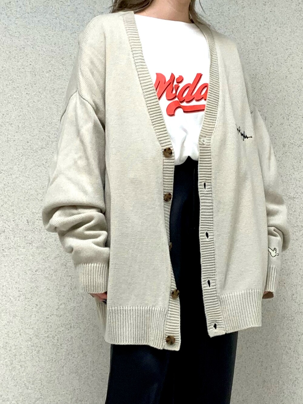 ホワイト系のカーディガン/ボレロ、ホワイト系のTシャツ/カットソー、ホワイト系のスニーカーを着用したレディースの秋コーディネートの2枚目の写真
