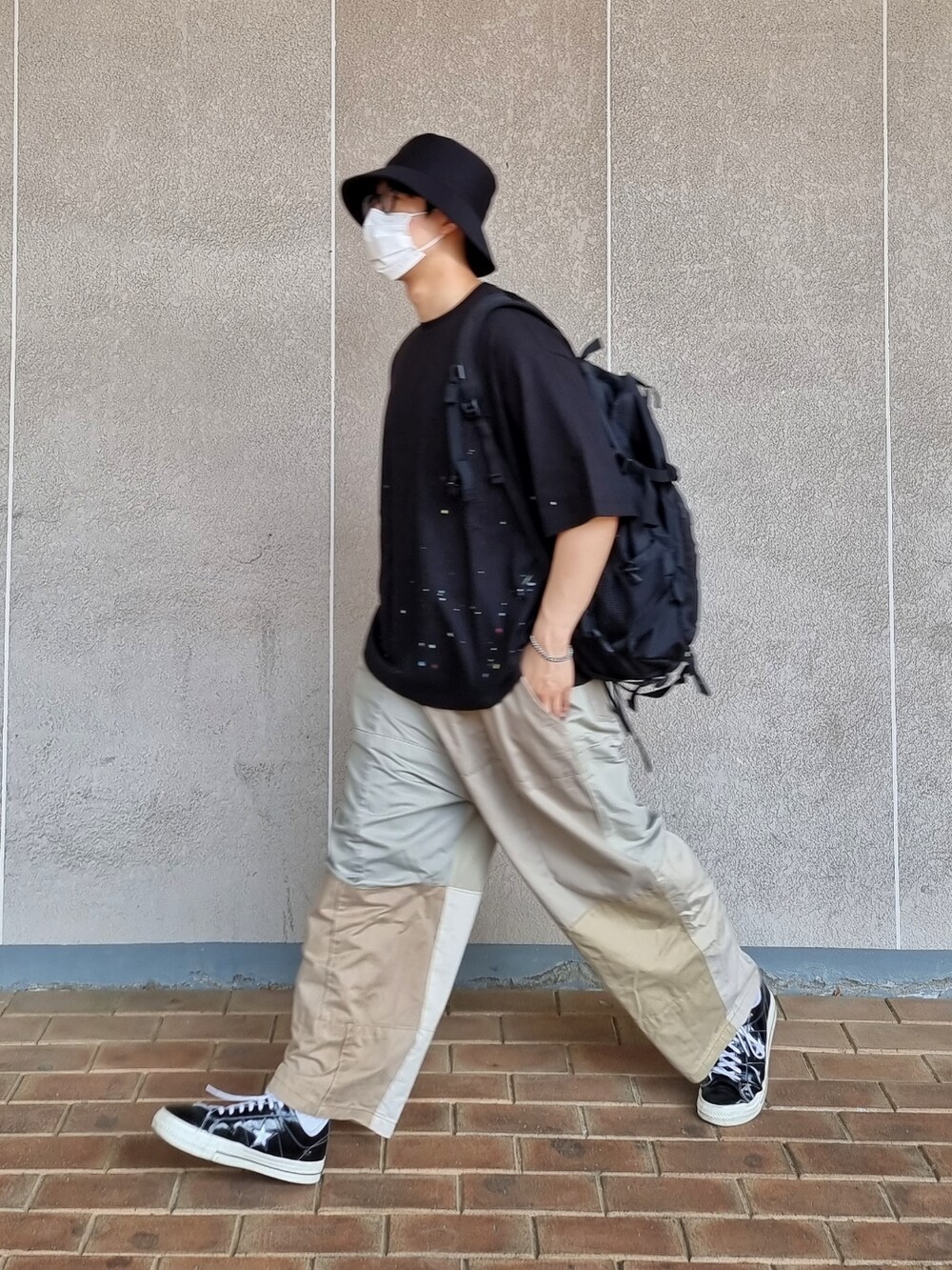 ブラック系のTシャツ/カットソー、その他のその他パンツ、ブラック系のスニーカーを着用したメンズの春コーディネートの3枚目の写真