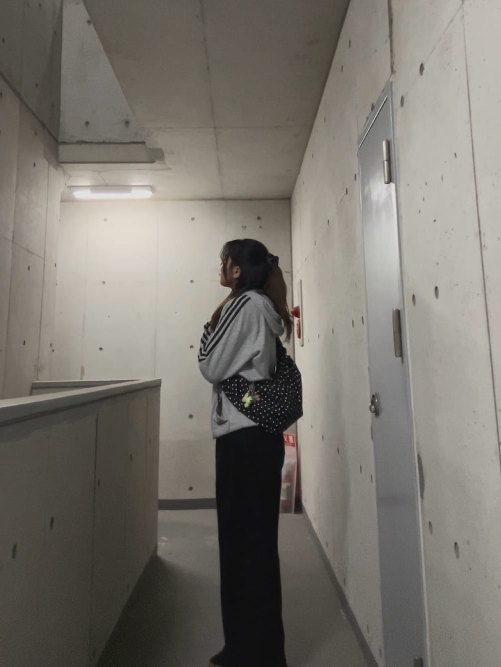 ブラック系のスラックス、グレー系のパーカー、その他のバッグを着用したレディースの春コーディネートの2枚目の写真