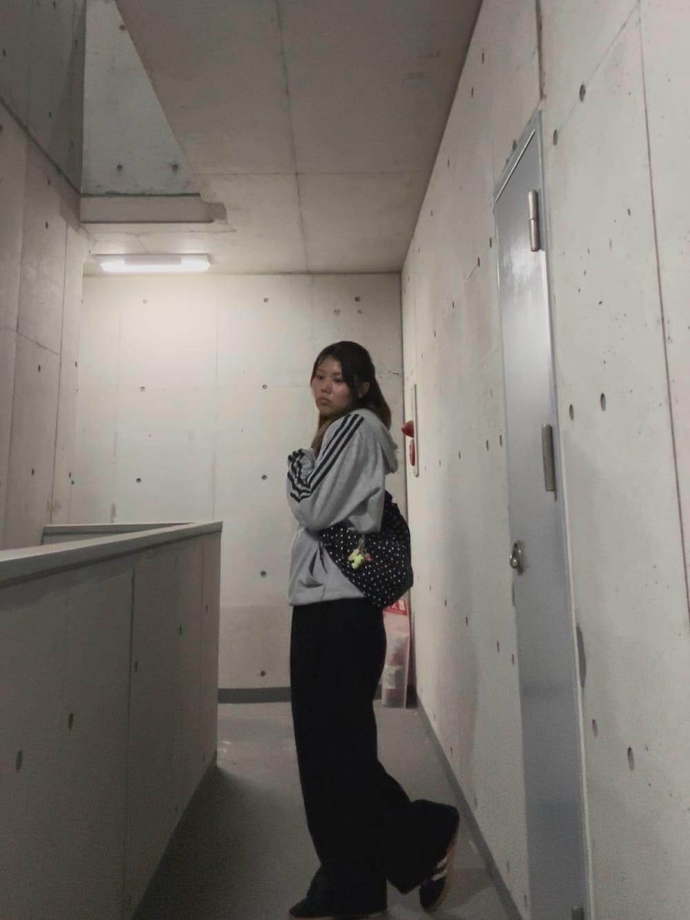 ブラック系のスラックス、グレー系のパーカー、その他のバッグを着用したレディースの春コーディネートの3枚目の写真