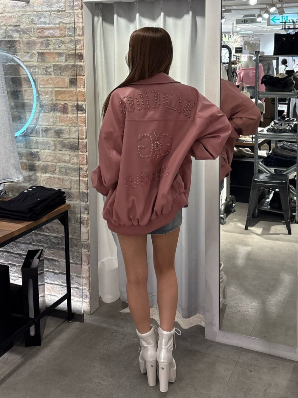 ピンク系のブルゾン、ホワイト系のTシャツ/カットソー、ブルー系のデニムスカートを着用したレディースの冬コーディネートの3枚目の写真