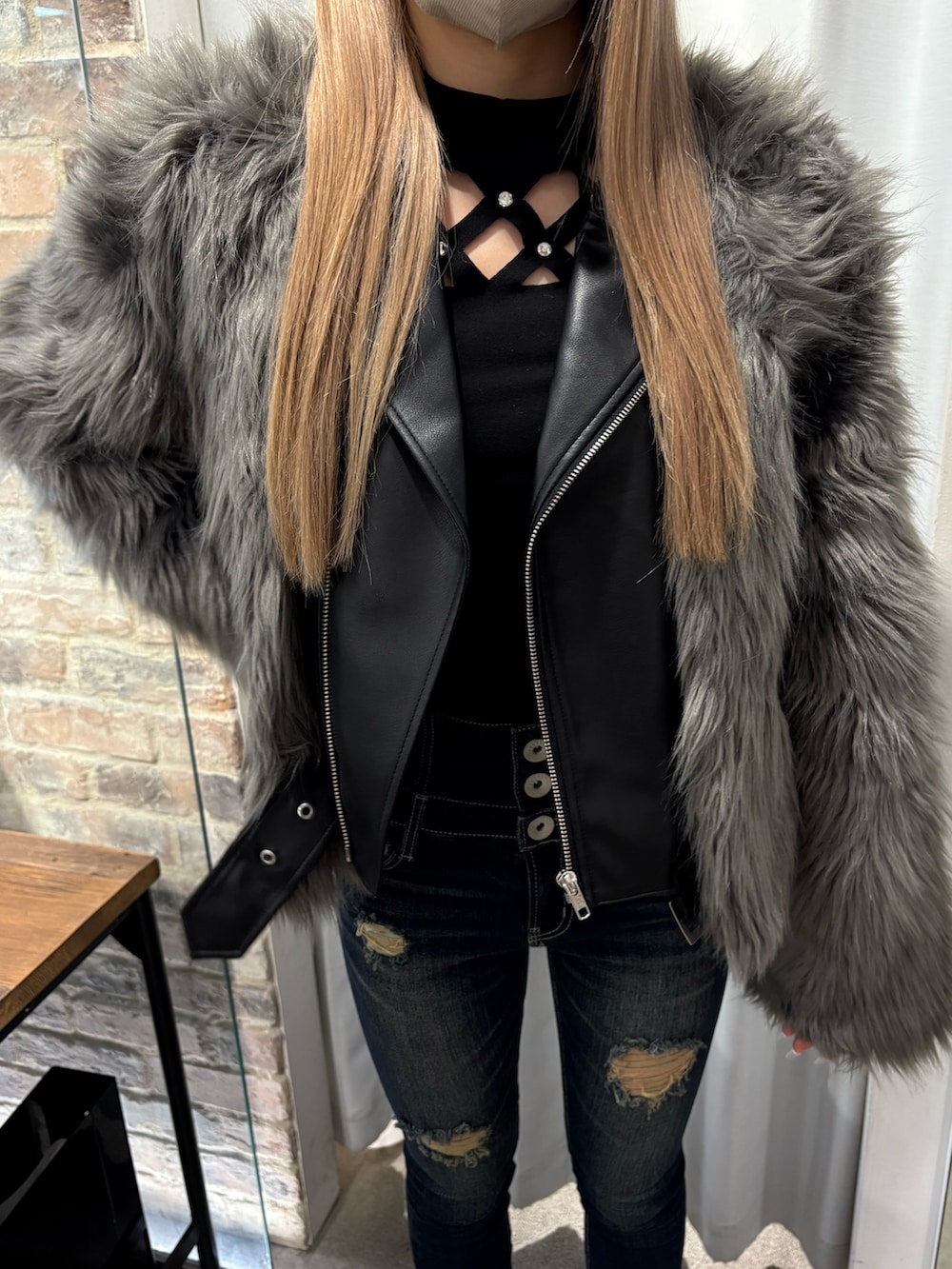 グレー系のライダースジャケット、ブラック系のTシャツ/カットソー、ブラック系のブーツを着用したレディースの冬コーディネートの4枚目の写真