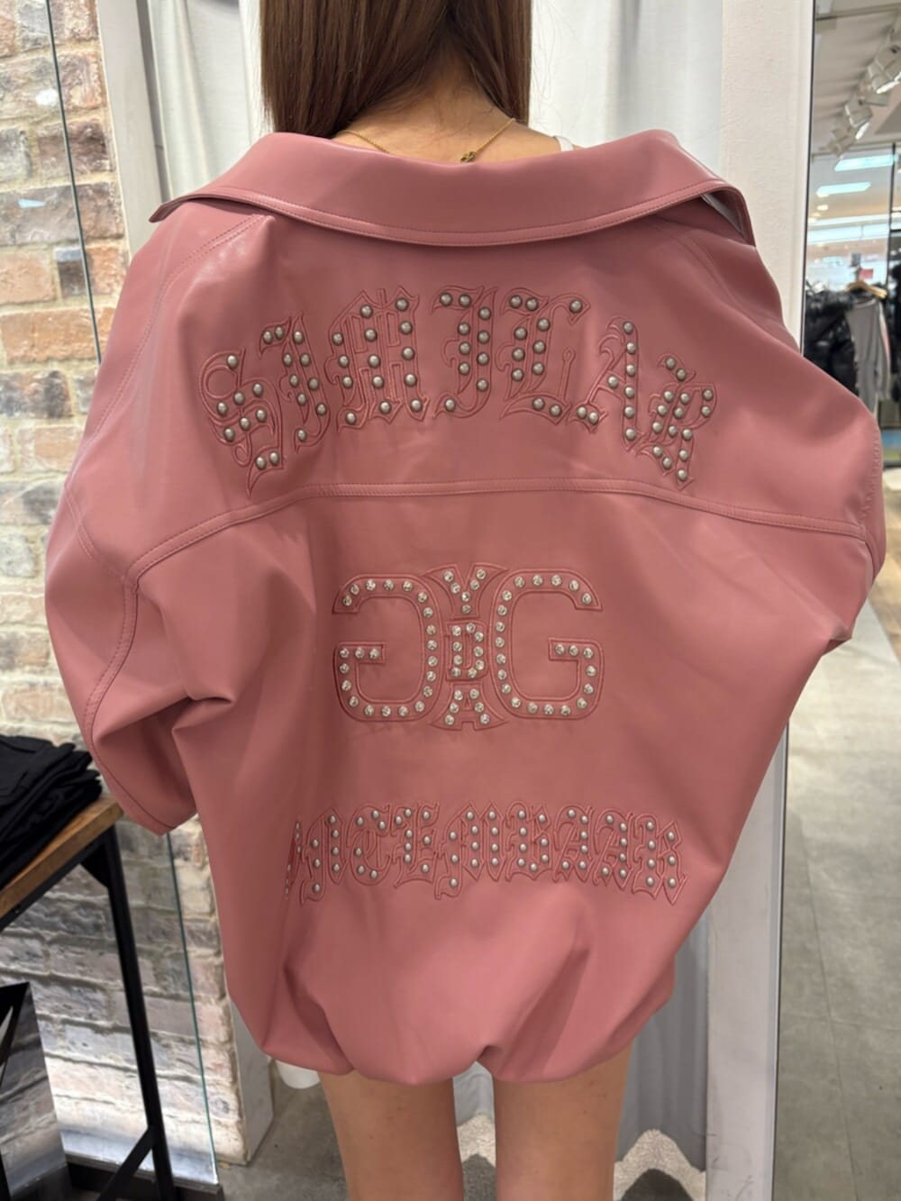 ピンク系のブルゾン、ホワイト系のTシャツ/カットソー、ブルー系のデニムスカートを着用したレディースの冬コーディネートの4枚目の写真