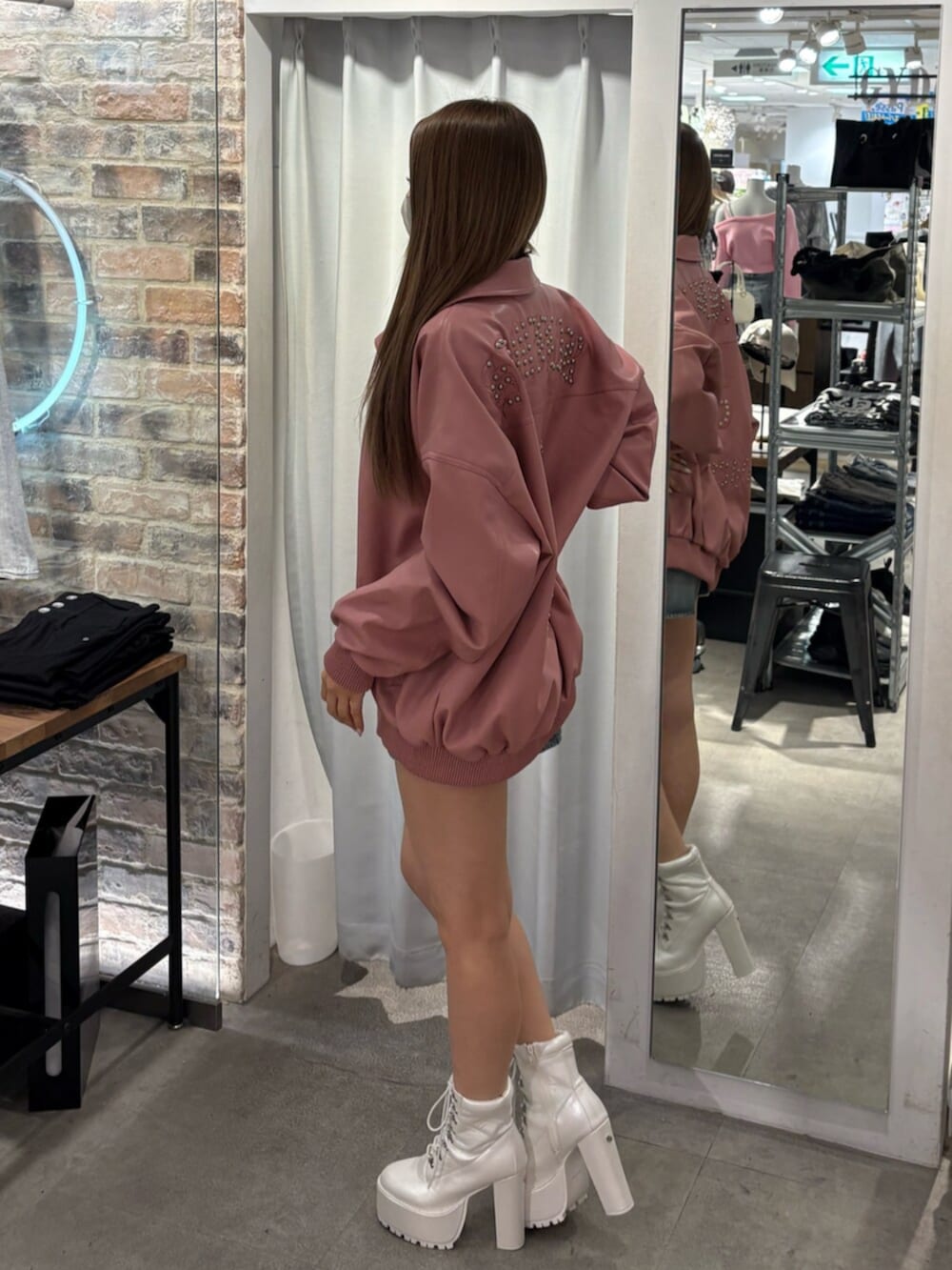 ピンク系のブルゾン、ホワイト系のTシャツ/カットソー、ブルー系のデニムスカートを着用したレディースの冬コーディネートの2枚目の写真