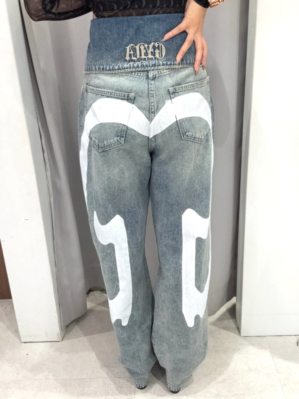 ブラック系のTシャツ/カットソー、ブルー系のデニムパンツ、ブラック系のブーツを着用したレディースの秋コーディネートの4枚目の写真