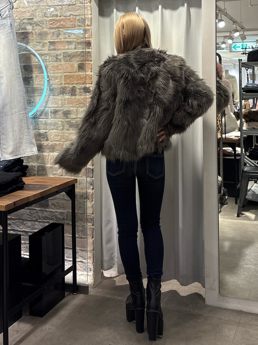 グレー系のライダースジャケット、ブラック系のTシャツ/カットソー、ブラック系のブーツを着用したレディースの冬コーディネートの3枚目の写真