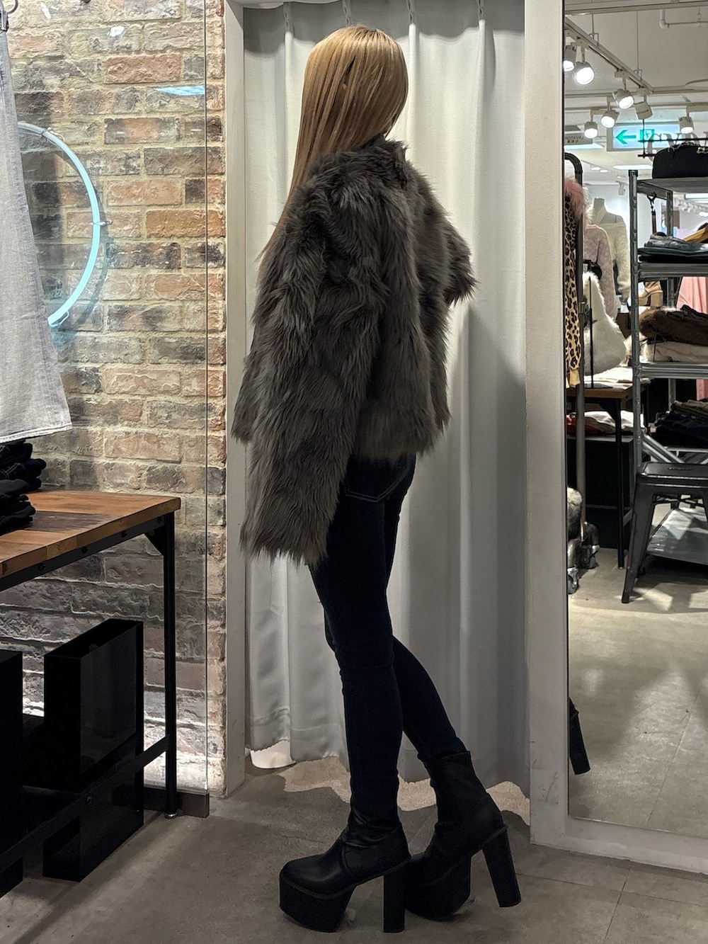 グレー系のライダースジャケット、ブラック系のTシャツ/カットソー、ブラック系のブーツを着用したレディースの冬コーディネートの2枚目の写真