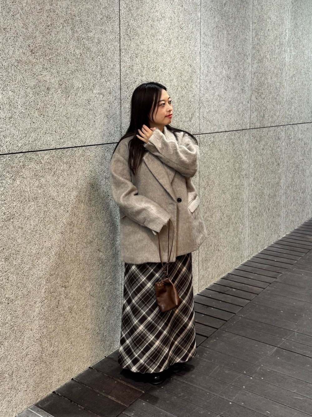 ブラック系のブーツ、ブラウン系のスカート、ブラウン系のショルダーバッグを着用したレディースの秋コーディネートの4枚目の写真