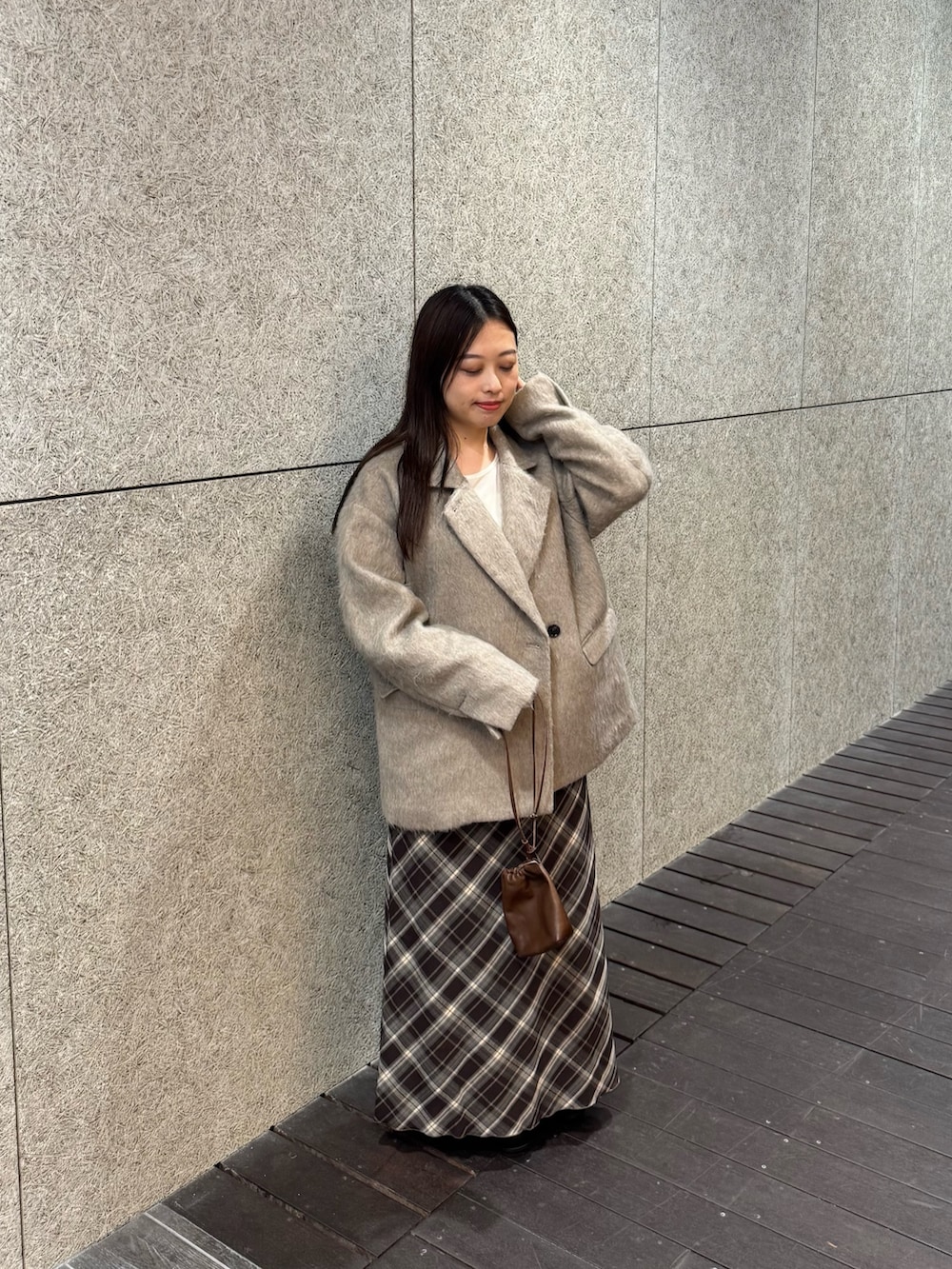 ブラック系のブーツ、ブラウン系のスカート、ブラウン系のショルダーバッグを着用したレディースの秋コーディネートの3枚目の写真