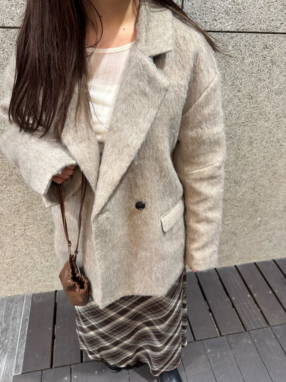 ブラック系のブーツ、ブラウン系のスカート、ブラウン系のショルダーバッグを着用したレディースの秋コーディネートの6枚目の写真